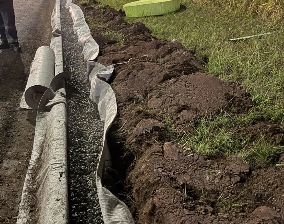 Gravel-lined trench beside grassy area